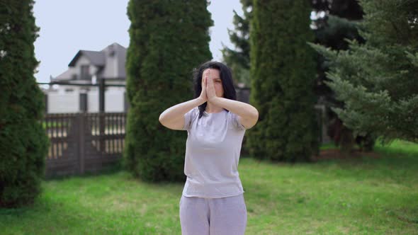 Beautiful Girl Practicing Yoga Alone in the Garden