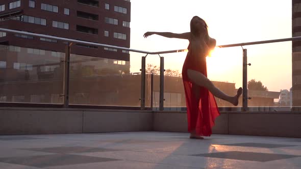 Beautiful Young Girl Dancing on the Street of a Modern City in the Sunset Light. She Is Wearing a