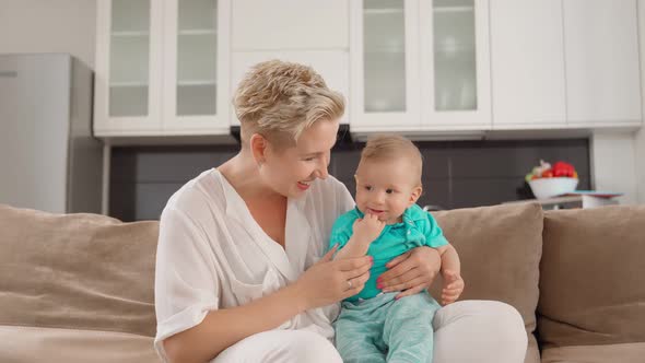 Mother Having Video Call While Sitting with Sons on Sofa