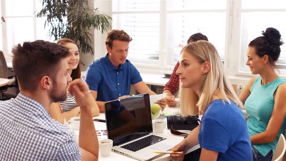 Male and female business executives interacting with each other in a meeting