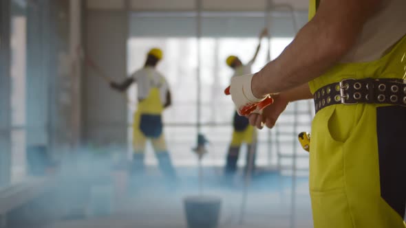 Close Up of Construction Worker Putting on Gloves Working in Office