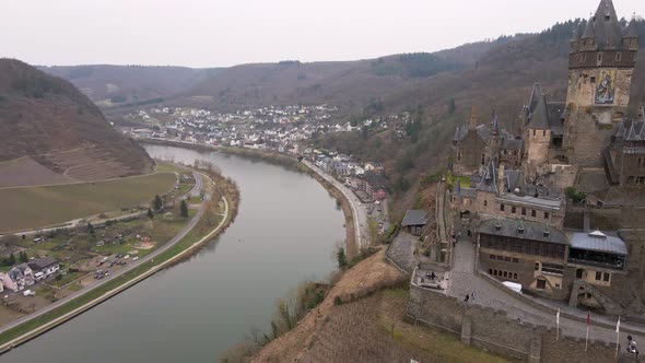 drone flight passes the cochem castle and over the river moselle with a wide view of the city