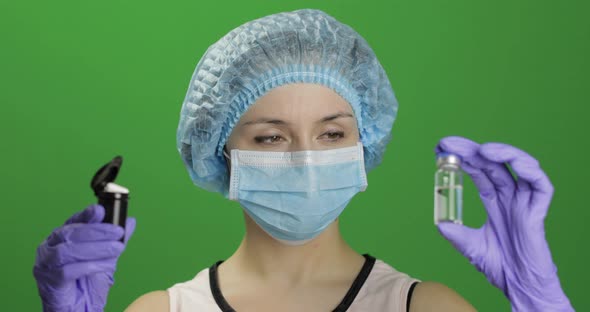 Female Scientist Chooses Ampoule of Vaccination or Plastic Jar with Pills alt