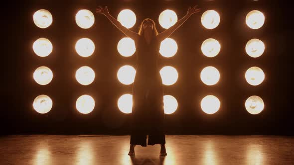 Beautiful woman dancing in front of a wall of lights