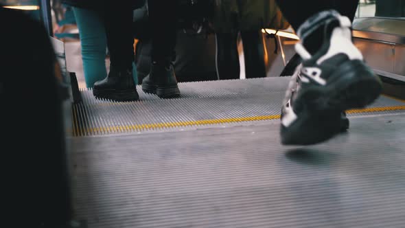 Legs of People Moving on an Escalator Lift in the Mall. Shopper's Feet on Escalator in Shopping