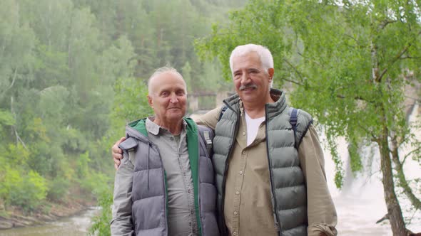 Happy Elderly Men Posing in front of Spillway
