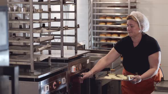 The Cook Is Putting the Bases for Donuts Into a Fridge