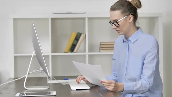 Paperwork By Young Casual Girl Working On Computer