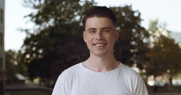 Portrait of Teenage Caucasian Young Man Tourist Student Stands Alone in Casual Clothes Outdoors in