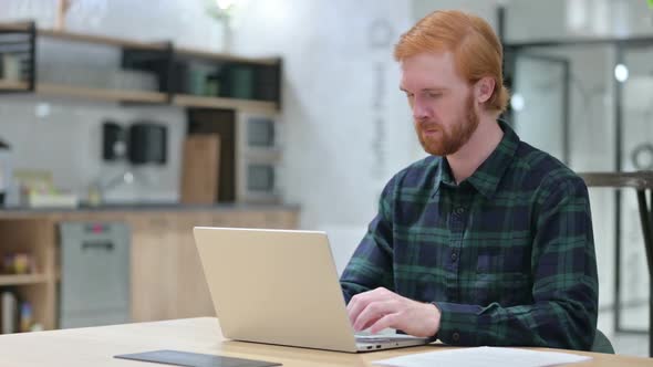Young Beard Redhead Man in Cafe Using Laptop