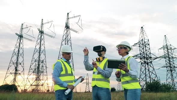 Three Specialists Observing Power Plant Using Modern Technology