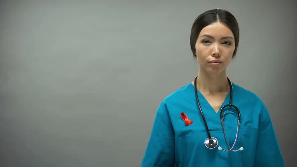 Asian Female Doctor With Red Ribbon, International HIV AIDS Awareness Sign