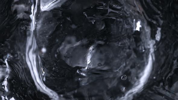 Super Slow Motion Macro Shot of Ice Cube Falling Into Glass With Vodka at 1000 Fps