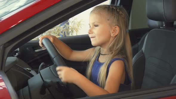 Beautiful Cute Girl Turns the Steering Wheel of a Car