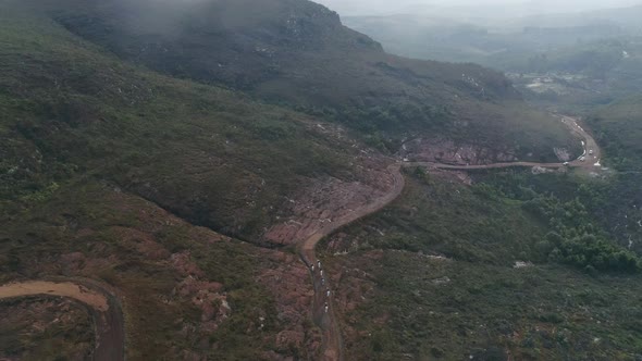 Aerial view of a group of horses across the road in the midle of the moutain. Minas gerais, Brazil.