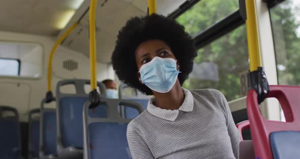 African american businesswoman with face mask sitting in bus