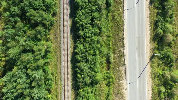 Asphalt Road and Train Railway at the Forest. Aerial View From Drone