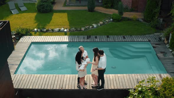 Big family laughing and chatting by the pool in a private cottage