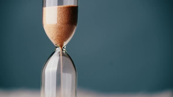 Countdown Hourglass Pouring on Blue Background