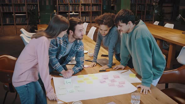 Millennial Business Team Analyze Project Draft on Large Paper Sheet