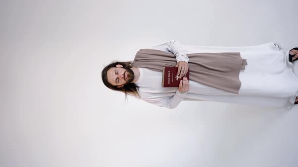 Jesus Raised the Bible in His Hands Above His Head on a White Background alt