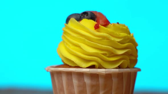 Cupcake with Yellow Sweet Cream is Spinning on a Blue Background