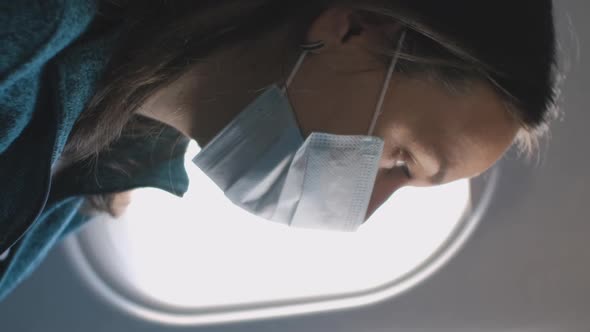 Woman Looking Through the Window in Airplane