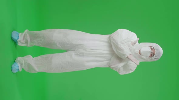 Asian Man Wear Protective Uniform PPE And Showing Stop Sign In The Green Screen Studio