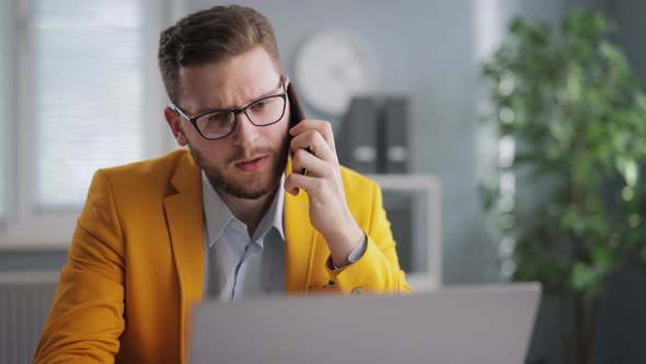 Man with Mobile and Laptop at Office