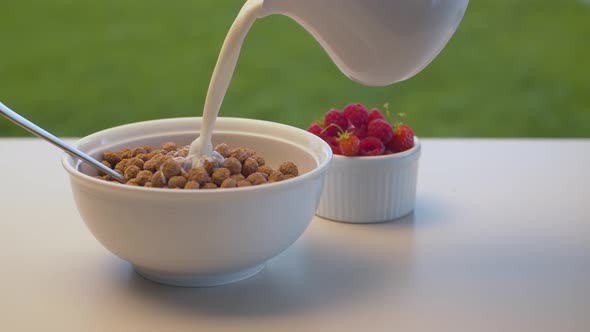 Milk pouring into corn flakes