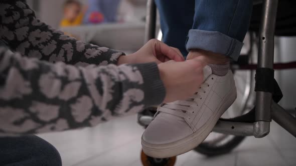 Hands of Girl Lacing Shoes for Disabled Grandma