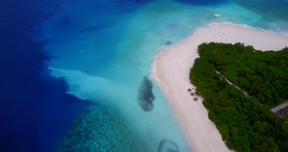 Wide drone abstract shot of a white sand paradise beach and blue ocean background in 4K