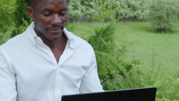 African-American businessman, works at a laptop in a cafe, freelancer