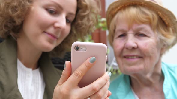 Granddaughter Teaching Grandma How To Use Smartphone