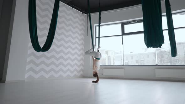 A Young Beautiful Woman Performs Exercises on a Hammock From Aero Yoga