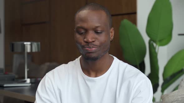 Young Black Man Sitting on the Couch Drinking Clean Water From a Glass