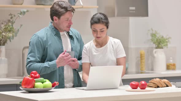 Mixed Race Couple Working on Laptop in Kitchen