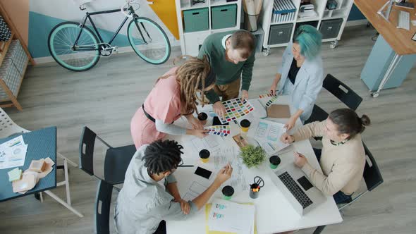 High Angle View of Business Group Discussing Colors for Mobile Applications in Office