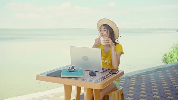 Woman Freelancer Using Laptop Computer on Beach By Sea