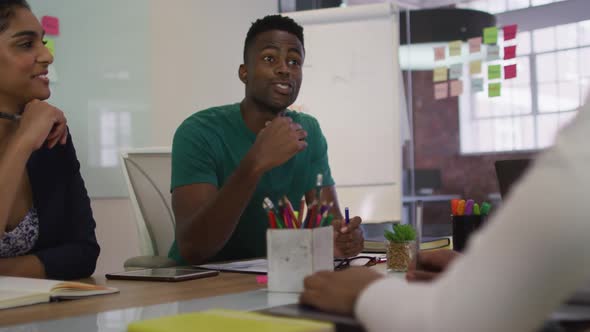 Mixed race business colleagues sitting having a discussion in meeting room