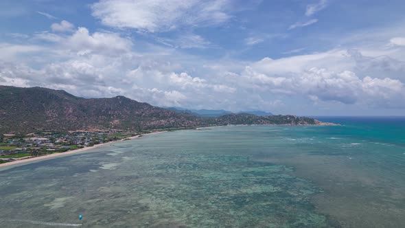 Magical view of moving clouds over kitesurfing lagoon. Aerial hyperlapse. Vietnam