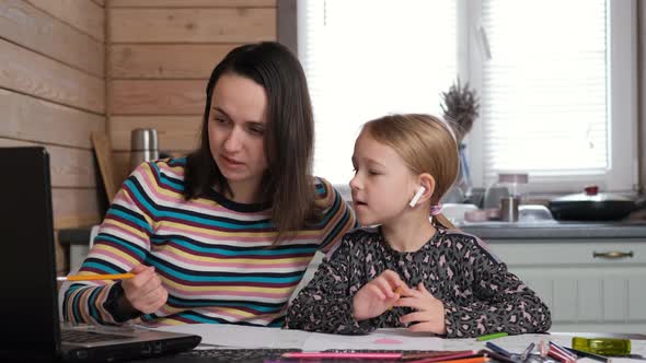 Little Girl with Mother Watching Online Lesson