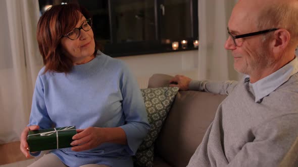 Happy Senior Couple with Gift Box at Home