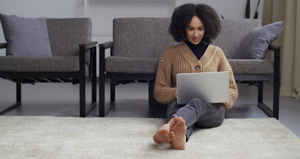 Afro American Black Mixed Race Woman Female Student Businesswoman Sitting on Floor on Living Room