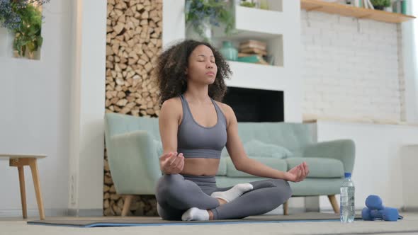 Young African Woman Meditating on Yoga Mat at Home