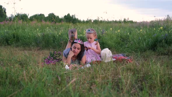 Young Mother with Little Daughter Reading Book