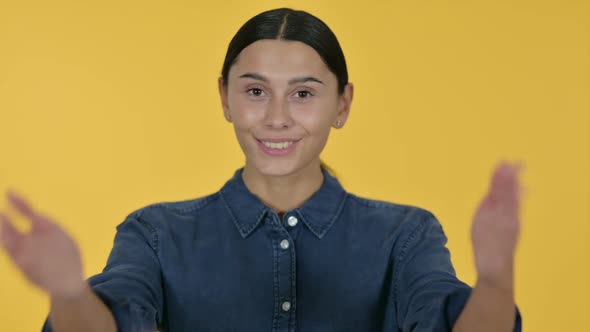 Latin Woman Pointing and Inviting Yellow Background