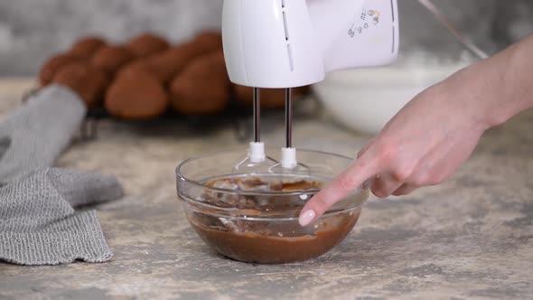 Professional Baker Whipped Chocolate Cream for Cake or Pastries in a Bowl