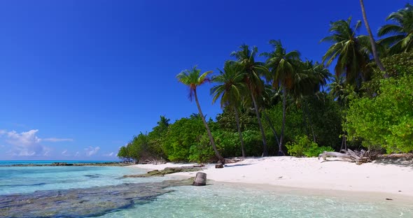 Daytime birds eye clean view of a paradise sunny white sand beach and blue water background in color