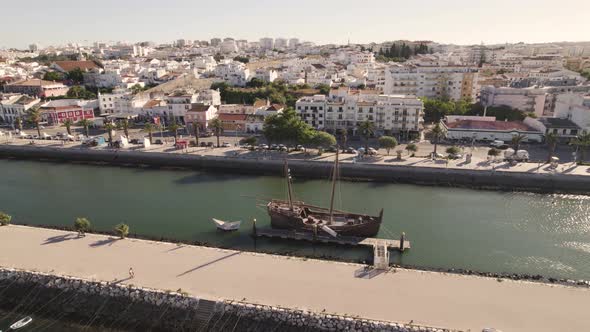 Old vessel sitting in the canal of Lagos, Portugal in front of the picturesque skyline